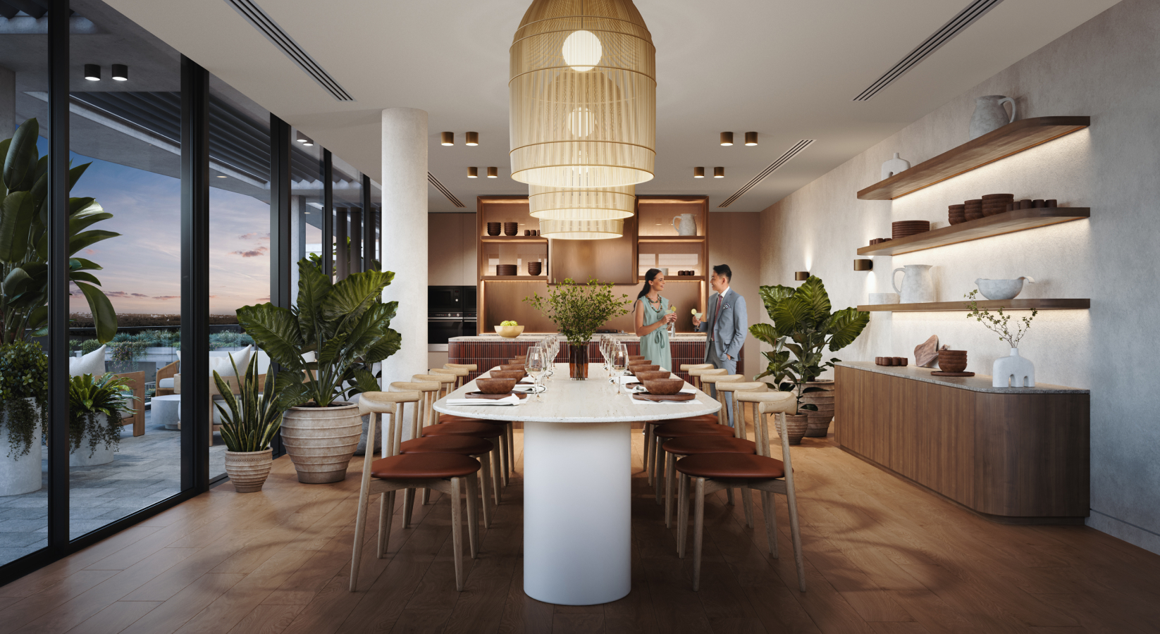 The Wentworth Quarter private dining room. A large modern dining table is in the centre, surrounded by chairs, stylish overhead lighting and decor. Full-length windows show the outdoor terrace with a dusky sky.